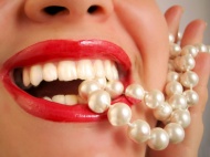 女性嘴唇含着珍珠链图片