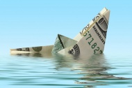 美元折成的纸船掉入水中图片